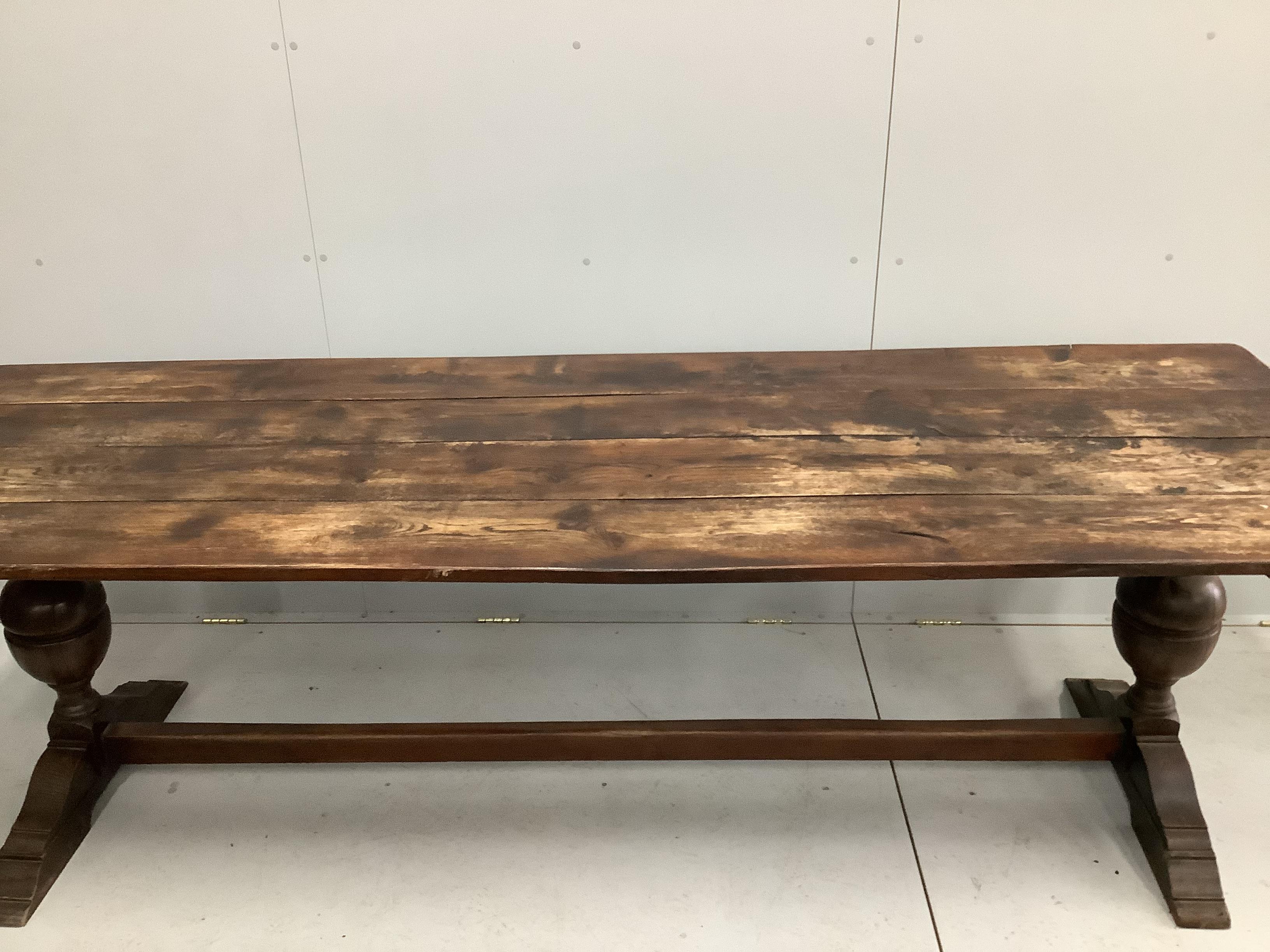 An 18th century style rectangular planked top oak refectory dining table, width 254cm, depth 84cm, height 75cm